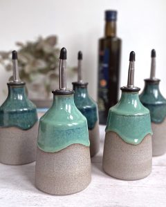 Handmade ceramic oil pourer. Grey stoneware with reactive green glazes