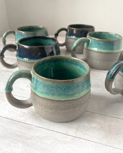 Handmade ceramic coffee mug. Grey stoneware with reactive green glazes